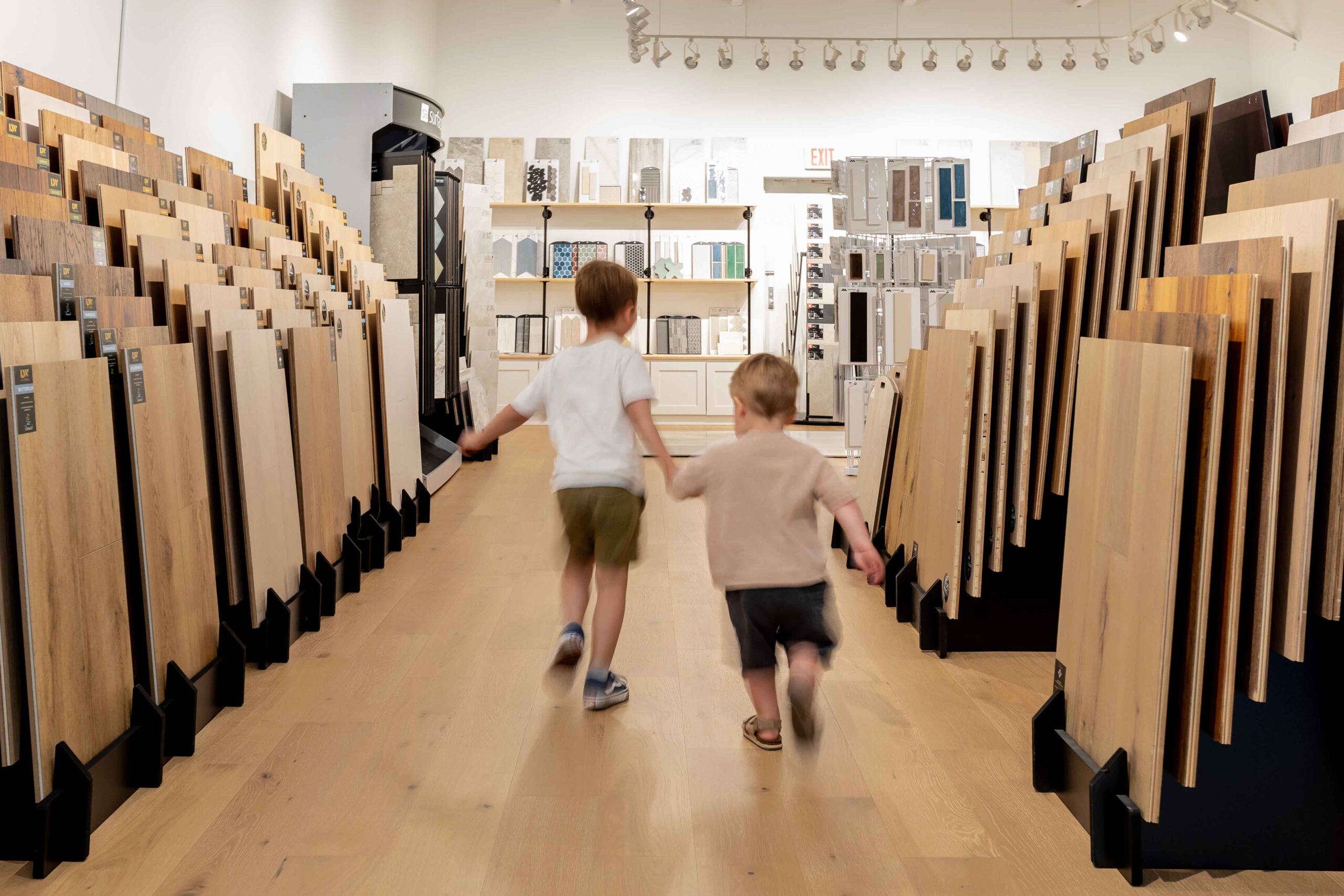 two little kids holding hands while walking