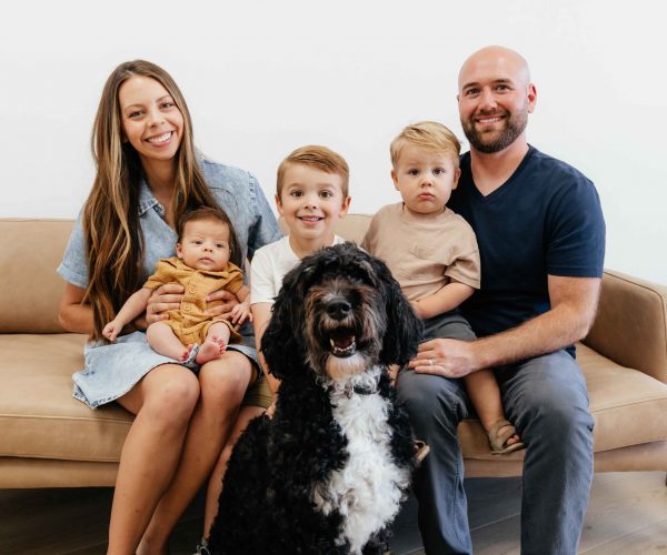 family picture sitting on the couch with their dog